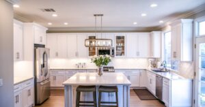 Home Spacious and elegant kitchen featuring white cabinetry, island, and stainless steel appliances.